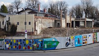 Der von Kindern liebevoll bemalte Bauzaun kann über den unerfreulichen Anblick auch  nicht hinweg täuschen (Foto: Unser Würmtal)